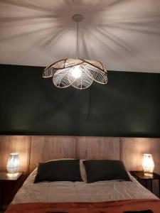 a bedroom with a bed with a green wall and a chandelier at Diseño Exclusivo, Parking y Vistas al Valle in Neuquén