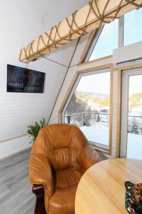 una silla de cuero marrón en una habitación con mesa en Cottage "A-FRAME romantic house", en Yaremche