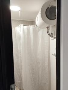 a bathroom with a shower curtain and a camera at Ξενώνας museum ισόγειο στο Ελληνικό Ιωαννίνων in Kalentzi