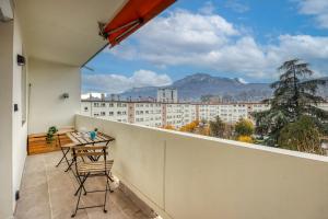 een balkon met een tafel en stoelen en uitzicht bij Le Boisé - Centre Ville / Calme in Grenoble