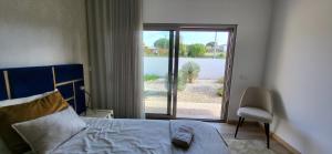Un dormitorio con una cama y una puerta corrediza de vidrio. en Villa Silver Coast, en Nadadouro 101 fotos más