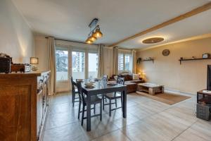 een keuken en een woonkamer met een tafel en stoelen bij Le Boisé - Centre Ville / Calme in Grenoble
