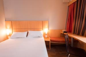 a bedroom with a bed and a desk and a chair at ibis Presidente Prudente Manoel Goulart in Presidente Prudente