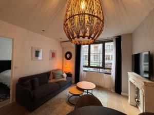 a living room with a couch and a chandelier at "Le petit bonlieu" au centre ville et à 500m du lac in Annecy