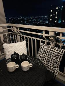 une table avec deux tasses et un sac sur un balcon dans l'établissement Rm’s Inn, à Manille