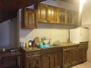 a kitchen with wooden cabinets and a sink at Apartman Ramić in Bihać