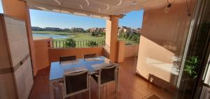 mit Blick auf einen Balkon mit einem Tisch und Stühlen in der Unterkunft Luxurious modern holiday flat on Mar Menor Golf Resort in Torre-Pacheco