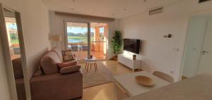 a living room with a couch and a television at Luxurious modern holiday flat on Mar Menor Golf Resort in Torre-Pacheco