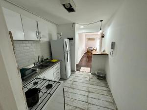 Il comprend une cuisine équipée d'un réfrigérateur blanc et du parquet. dans l'établissement Departamento Pancho Ramirez, à Concordia