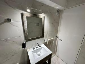une salle de bain avec un lavabo et un miroir dans l'établissement Departamento Pancho Ramirez, à Concordia