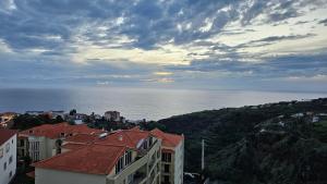 uma vista para o oceano a partir de uma cidade com edifícios em Sunset Star with Sea View na Calheta