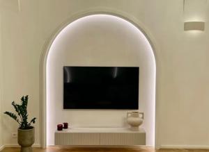 uma arcada com uma televisão numa sala de estar com uma planta em Exclusive Apartment in Praga em Praga
