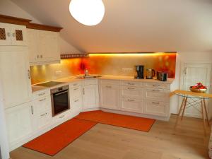 a kitchen with white cabinets and an orange rug at Alpenstern Ferienwohnung in Pfronten