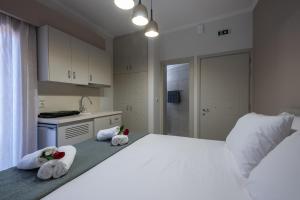 a bedroom with a large white bed with towels on it at OLYMPIA ROOMS in Myrina