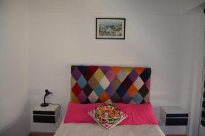 Dormitorio con cama con cabecero colorido en Cleopatra en Buenos Aires