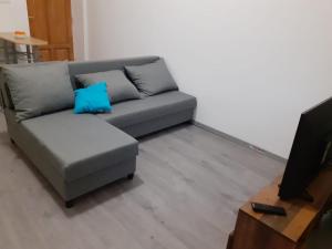 un sofá gris con una almohada azul en la sala de estar en Fantomas*** N4 City Center Apartments 3 Bedroom + Living room en Szombathely