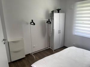 a white room with a bed and a refrigerator at Apartment in Maribor in Maribor