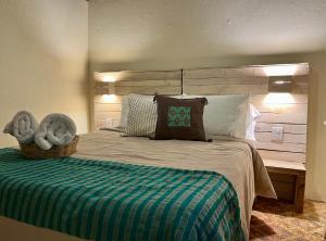 1 dormitorio con 1 cama grande y cabecero de madera en Casa Cheleb en San Cristóbal de Las Casas