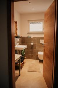 a bathroom with a toilet and a sink at Wohnung Schrödelstein in Lenggries