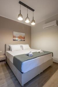a bedroom with a large bed with two towels on it at OLYMPIA ROOMS in Myrina