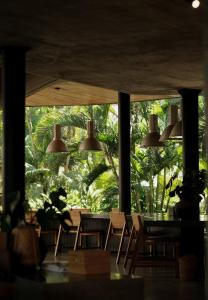 a dining room with a table and chairs and a large window at Wave House - Surf Camp in Canggu