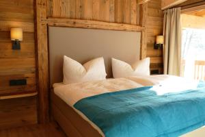 um quarto com uma cama e uma parede de madeira em Chalet - Das Schrofen em Ramsau im Zillertal