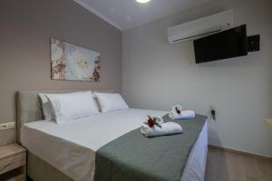 a bedroom with a bed with two stuffed animals on it at OLYMPIA ROOMS in Myrina