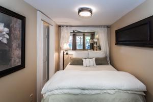 a small bedroom with a white bed with a window at Cozy Apartment in Downtown Neighborhood in Columbia