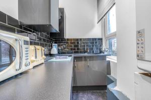 a kitchen with a stove and a microwave at Cosy modern city centre flat in Edinburgh