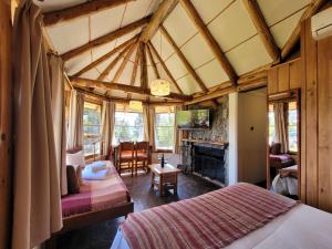 1 dormitorio con 2 camas y chimenea en Apart Hotel Del Arroyo en San Carlos de Bariloche
