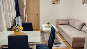 een woonkamer met een bank en een tafel bij Apartman Rubikon in Kumanovo