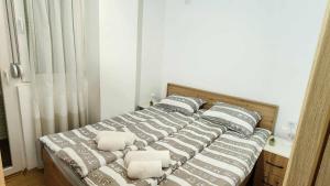 een bed met kussens in een slaapkamer bij Apartman Rubikon in Kumanovo