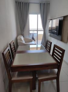 un tavolo da pranzo con 2 sedie e un divano di APARTAMENTO - GUILHERMINA - PRAIA GRANDE a Praia Grande