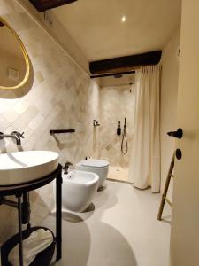 uma casa de banho com 2 lavatórios, um WC e um chuveiro em Castel Di Luco em Acquasanta Terme