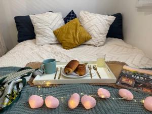 uma bandeja com um prato de doces numa cama em Bel appartement Antony, 8min RER B à pied, proche Paris et Orly em Antony