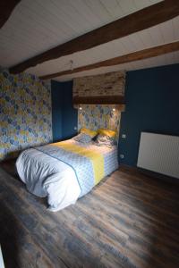um quarto com uma cama com uma parede azul em Gîte de Bena em Chaunay