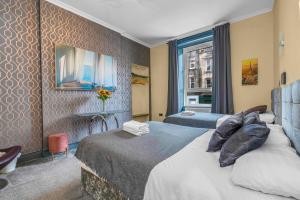 a hotel room with two beds and a window at Cosy modern city centre flat in Edinburgh