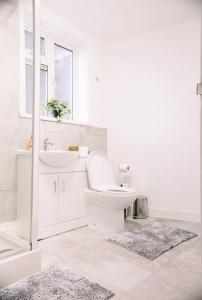 a white bathroom with a toilet and a sink at 6 bedroom property in Sidcup