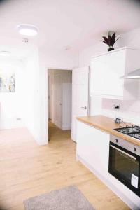 a kitchen with white cabinets and a stove top oven at 6 bedroom property in Sidcup
