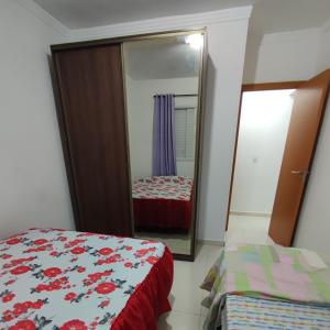 um quarto com um espelho e uma cama em APARTAMENTO - GUILHERMINA - PRAIA GRANDE na Praia Grande