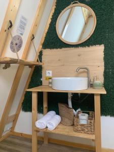 a bathroom with a sink and a mirror and towels at Casutele din Poienita in Comarnic