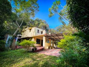 a house in the middle of a yard at Comfort Cottage in Yercaud