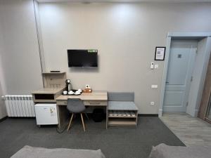 a room with a desk and a tv on a wall at Mini Hotel in Tashkent