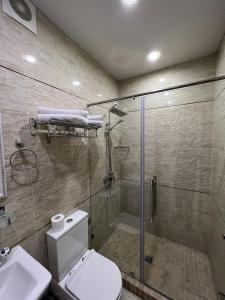 a bathroom with a shower and a toilet and a sink at Mini Hotel in Tashkent