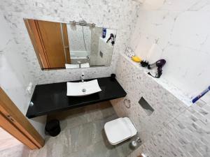 a white bathroom with a sink and a mirror at Sudresidence in Agadir