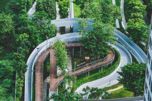 a building in the middle of a forest with a road at Ideo O2 BTS Bangna in Bangkok