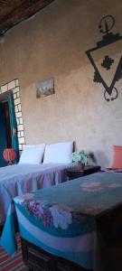 - une chambre avec 2 lits et un mur dans l'établissement Oasis travel, à Tazouka