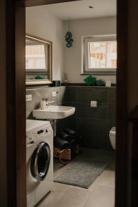 a bathroom with a washing machine and a sink at Wohnung Finstermünz in Lenggries