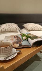 stół z filiżanką kawy i książką w obiekcie Luxury Room Well Located w mieście Częstochowa