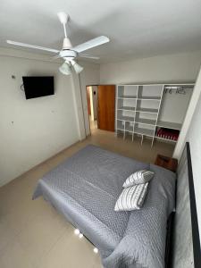 1 dormitorio con 1 cama y ventilador de techo en Apartamento Roma en Mar de Ajó
